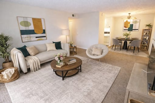 A living room with a white couch, a coffee table, and a painting on the wall.