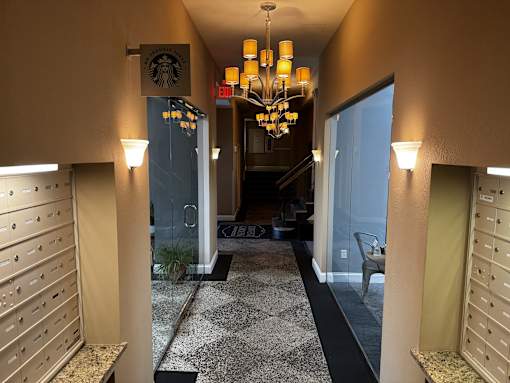 A hallway with a chandelier and a Starbucks sign on the wall.