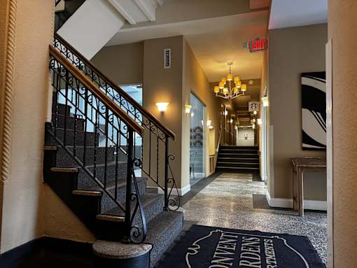A lobby with a staircase and a sign that says Starbucks
