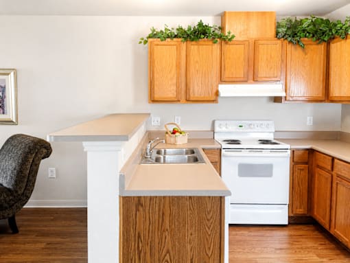 A kitchen with wooden cabinets and a white stove.