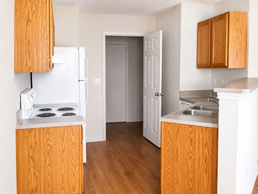 A kitchen with wooden cabinets and a white fridge.