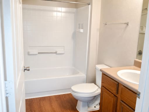 A white toilet sits in a bathroom next to a sink.