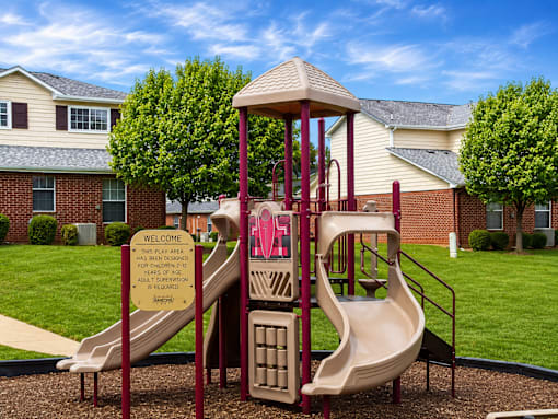 A playground with a slide and a sign that says "Welcome".