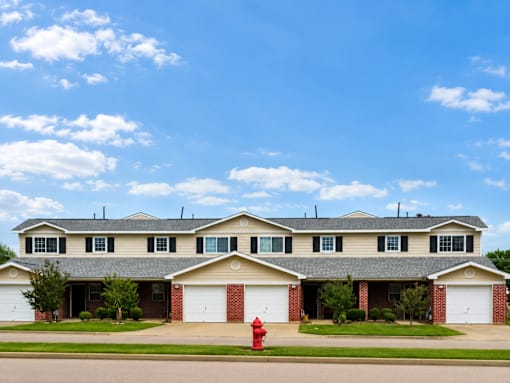 A large house with a red fire hydrant in front.