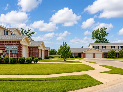 A suburban neighborhood with houses and well-maintained lawns.