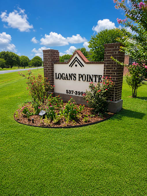 A sign for Logan's Pointe with a phone number on it.