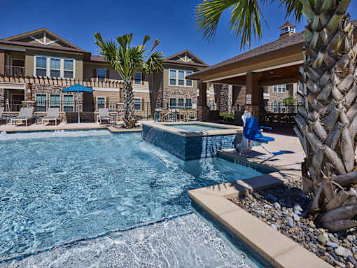 A person is sitting on a blue chair by a pool.