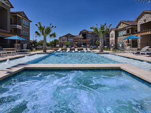 A large pool with a hot tub in the middle of a residential area.