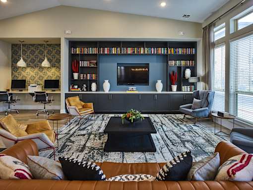 A living room with a brown leather couch and a black coffee table in the center.