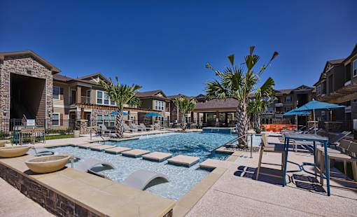 A pool with a slide and a palm tree in the foreground.