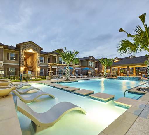 A large outdoor swimming pool with a slide and loungers.