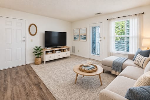 A living room with a flat screen TV and a coffee table.