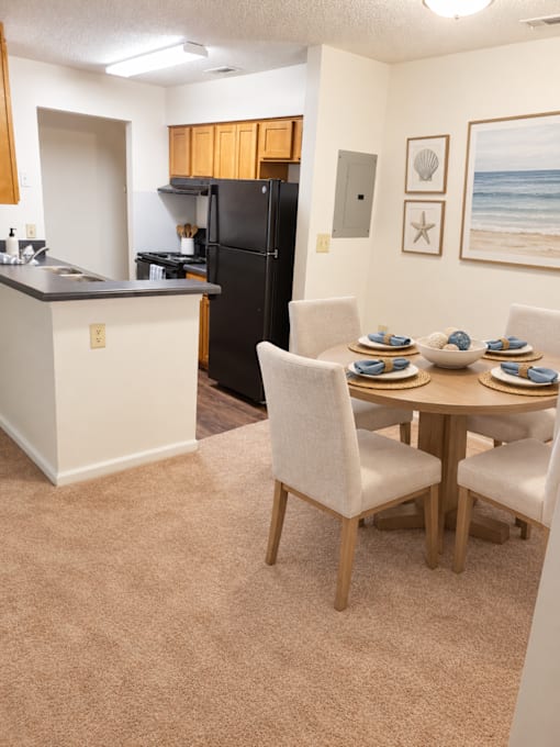 A kitchen with a table set for four.