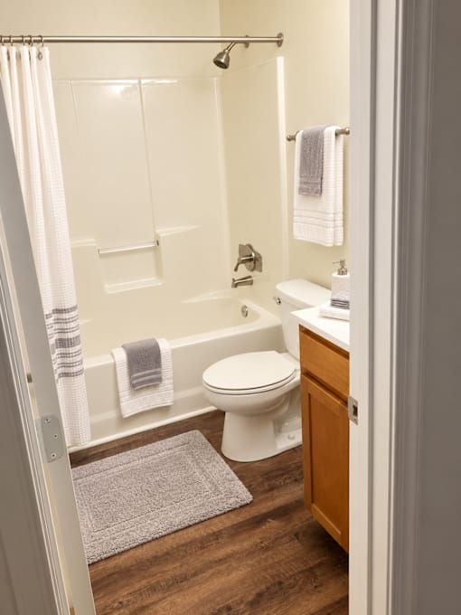 A white toilet is in a bathroom with a white shower curtain.