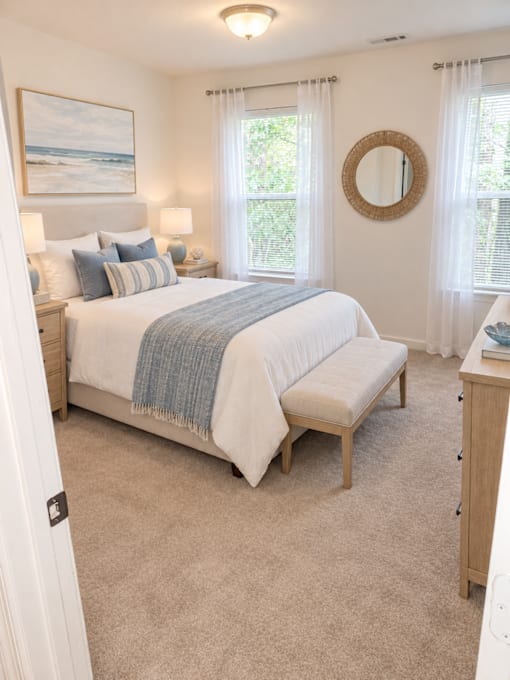 A bedroom with a bed, nightstands, and a window.
