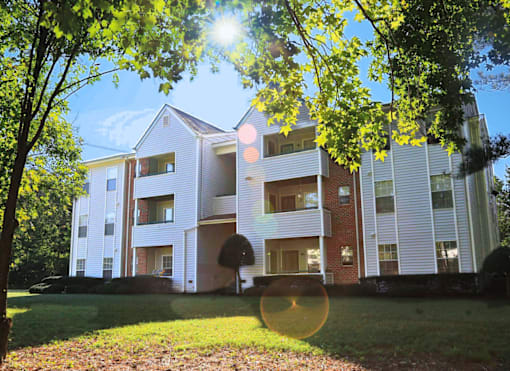 A modern apartment building with a white facade and multiple balconies.
