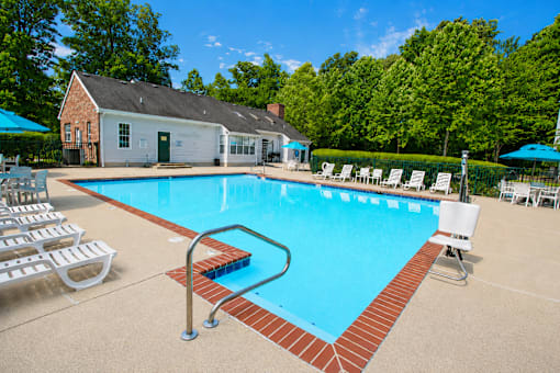A pool with a red brick border and a diving board.