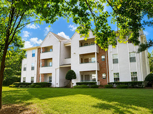 A white building with a tree in front of it.