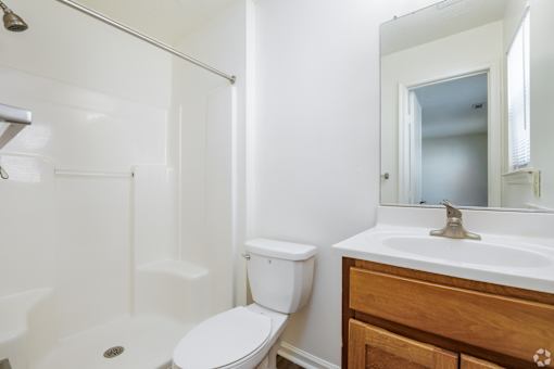 A white toilet sits next to a white sink in a bathroom.