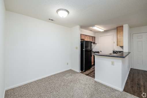 A kitchen area with a black refrigerator and a white countertop.