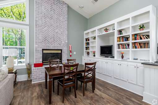 A living room with a fireplace and a dining table.