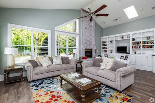 A living room with a grey couch, a coffee table, and a ceiling fan.