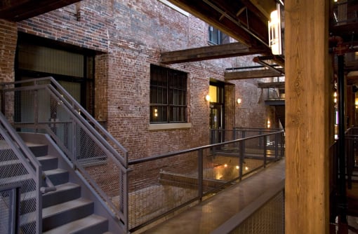 the interior of a building with stairs and a brick wall