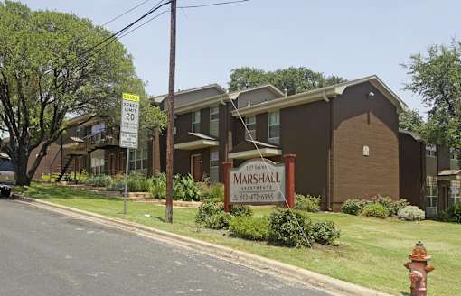 A house with a sign that says Marshall in front of it.