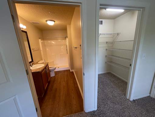 A bathroom with a toilet, sink, and mirror is shown.