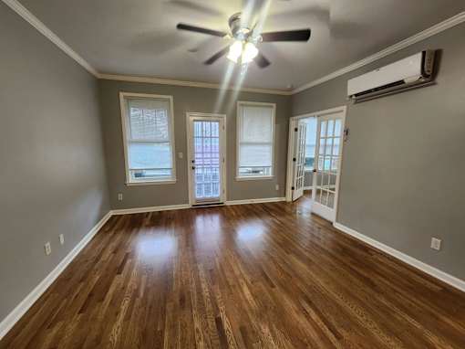 A room with wooden floors and a ceiling fan.