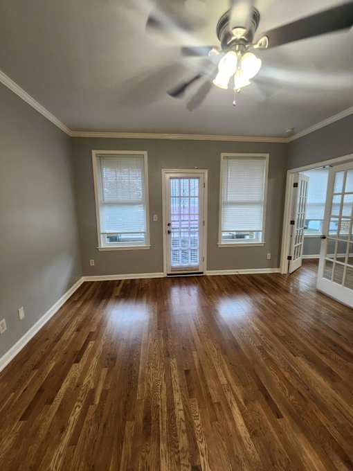A room with wooden floors and a ceiling fan.