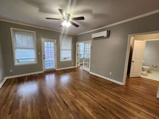 A room with wooden floors and a ceiling fan.