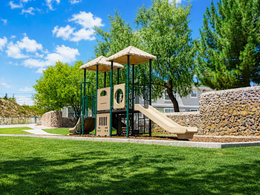 A playground with a slide and a swing set.