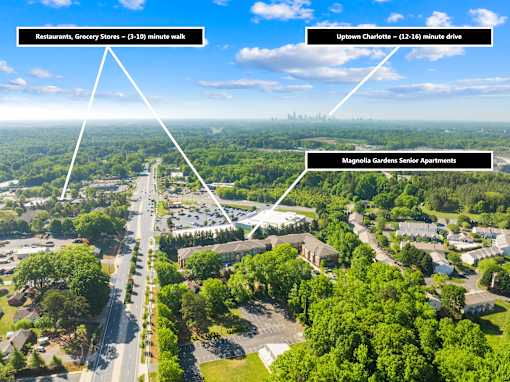 An aerial view of a neighborhood with a road and greenery.