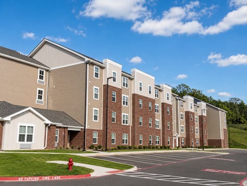 A large apartment complex with a fire hydrant in front of it.