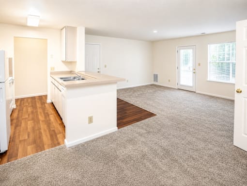 A kitchen with white appliances and a white island with a sink.