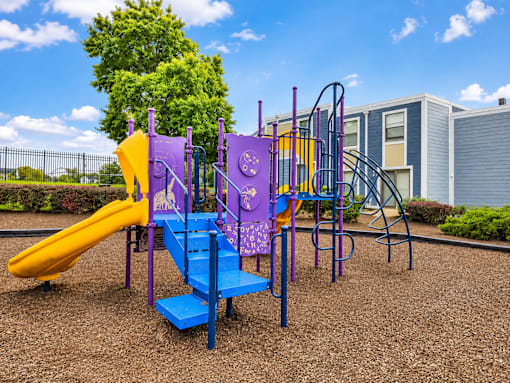A playground with a purple and yellow slide.