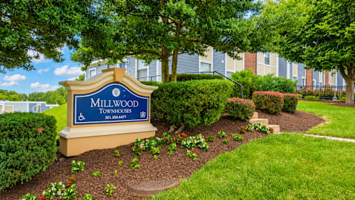 A sign that says Millwood in front of some buildings.