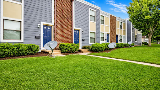 A row of apartment buildings with blue doors and windows.