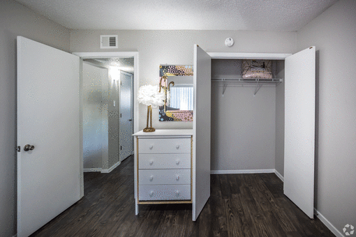 a walk in closet with a white dresser with a lamp on top of it at Azure Place Apartments, Memphis, TN, 38118