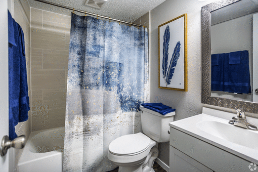 a bathroom with a white toilet next to a bathtub at Azure Place Apartments, Tennessee, 38118
