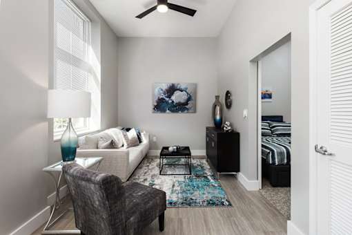 A living room with a grey armchair and a white sofa.