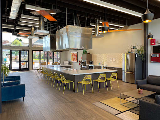 A modern kitchen with a long island and yellow chairs.