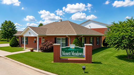 The image shows a building with a sign that reads "Monett Meadows.".