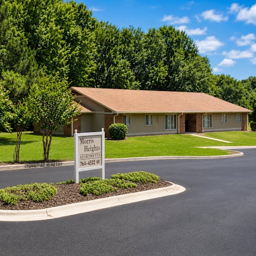 A sign for Morris Heights Apartments is in the foreground of a well-manicured lawn.