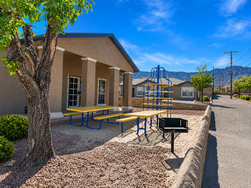A small building with a playground in front of it.