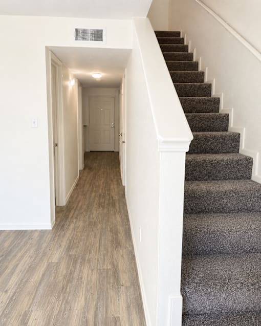A staircase with a carpeted runner and wooden steps.