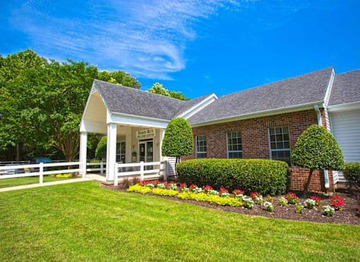 A house with a white fence and a garden in front.