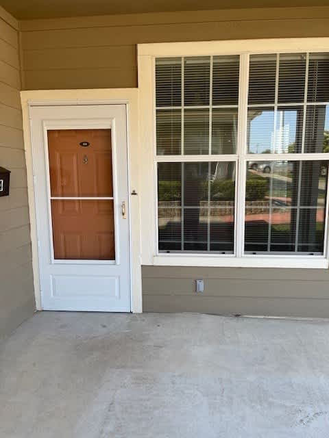 A brown door is on the left and a window with blinds is on the right.