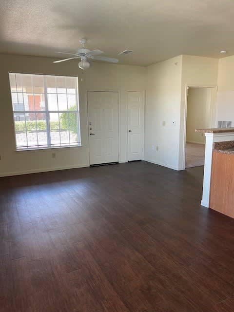 A room with a ceiling fan and wooden flooring.